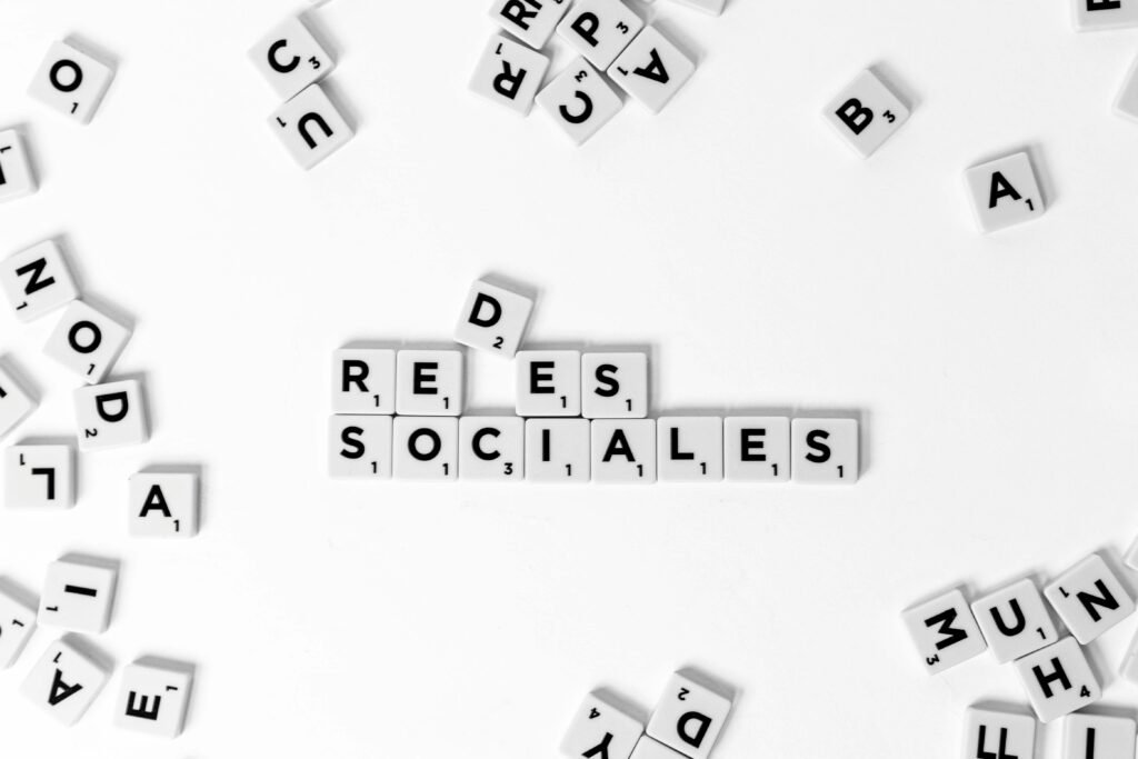 Scrabble tiles spelling 'Redes Sociales' on a white background, concept for social networks.