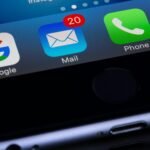 A close-up photo of a smartphone displaying popular apps like Google and Mail.